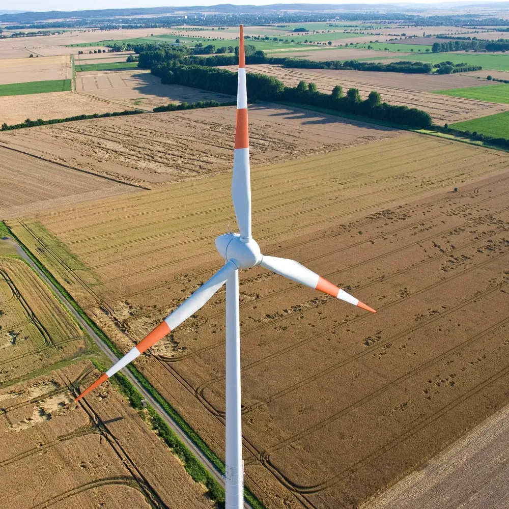 Luftbild einer einzelnen Windkraftanlage in einem abgeernteten Feld