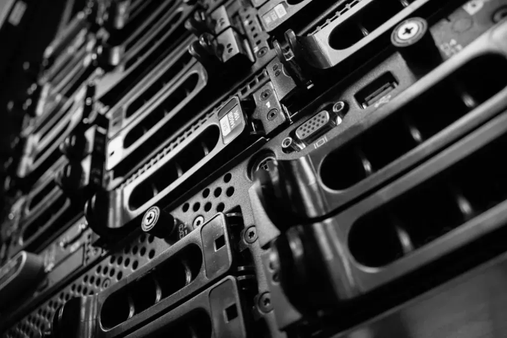 Close-up black and white shot of several computer server hard drive bays in a server rack.